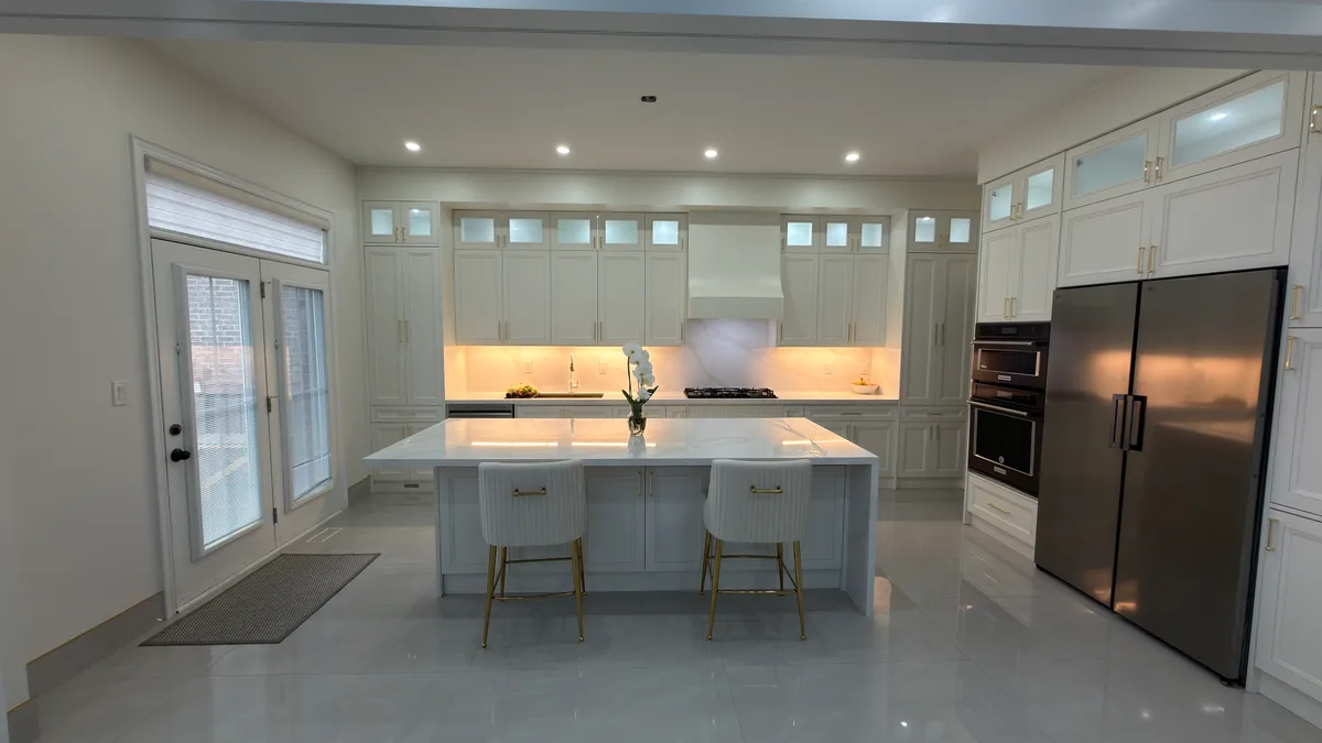 White cabinetry, a generous island and warm lighting give this kitchen a completely different feel