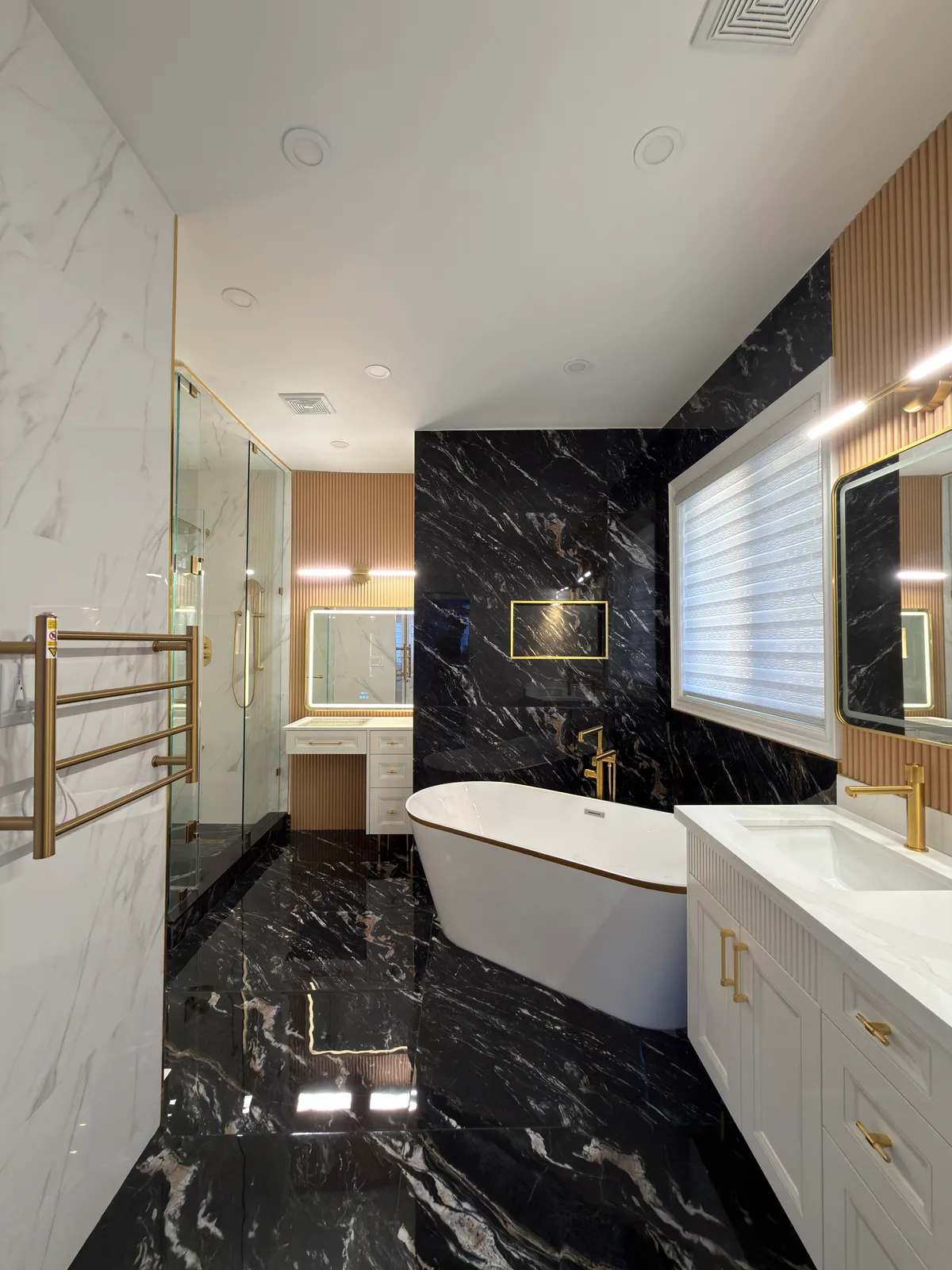 A freestanding bathtub, glass shower and contrasting marble-look surfaces turn this primary bathroom into a distinctive retreat