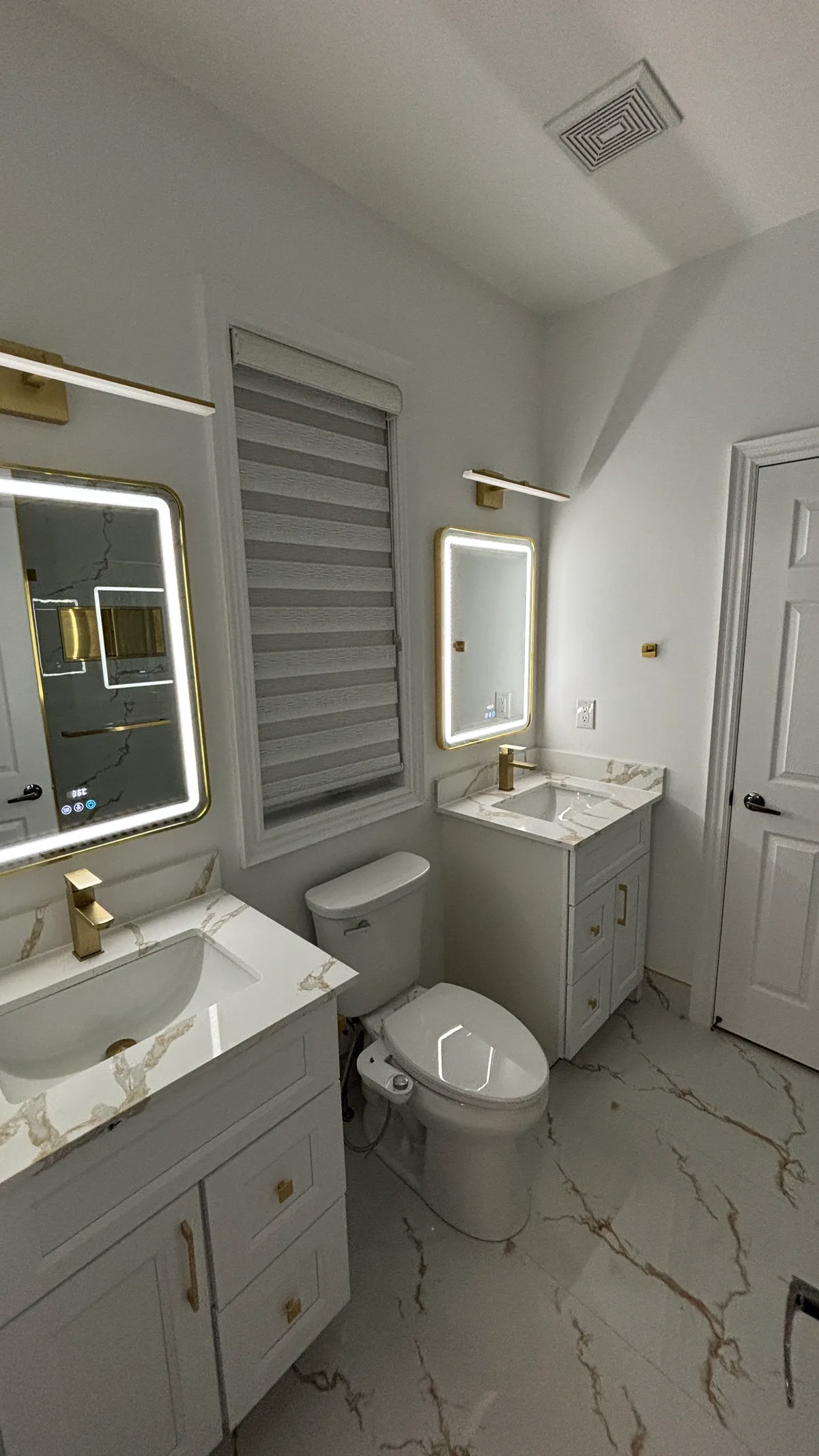 Light surfaces and gold-toned details give this compact bathroom its character